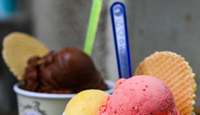 Eisbecher mit Kugeln verschiedener Sorten Eis stehen auf einem Tisch.
