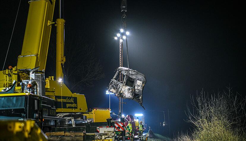 Mit einem gro&szlig;en Kran und unter Flutlicht werden Tr&uuml;mmerteile geborgen.
