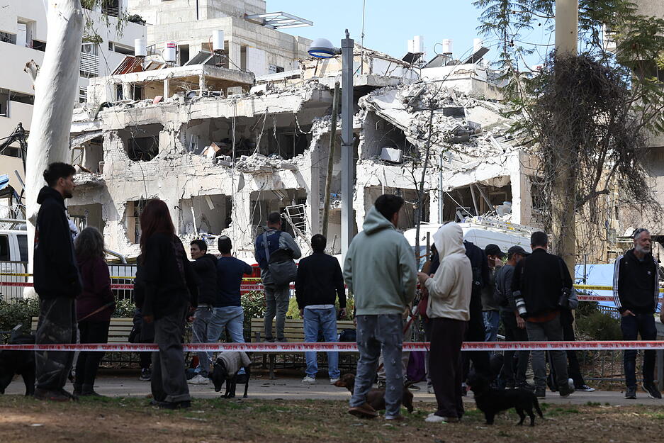In Tel Aviv (Israel) betrachten Menschen die Sch&auml;den nach dem Einschlag einer iranischen Rakete.
