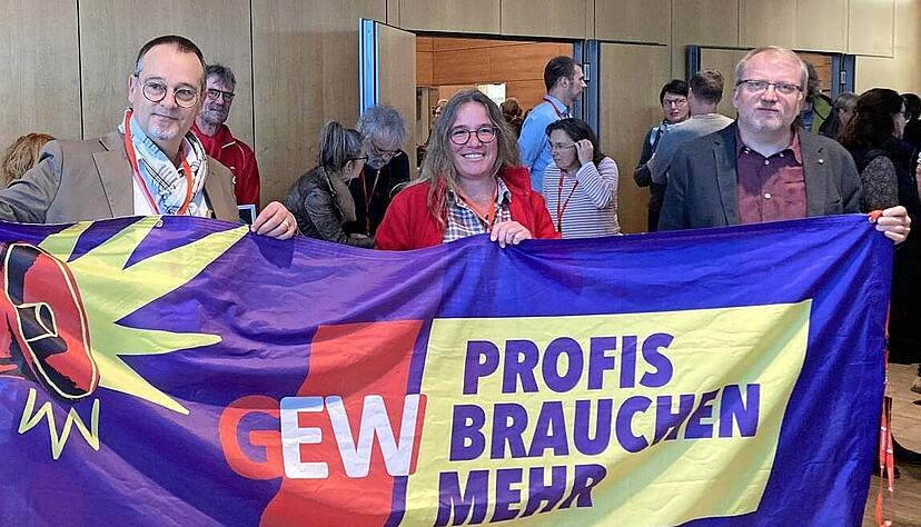Harald Schr&ouml;der, Barbara B&uuml;rgy und Martin Hettler (von links) halten in der Mittagspause der Personalversammlung in der Flina die GEW-Fahne hoch.
Foto: Schwarzb&uuml;rger