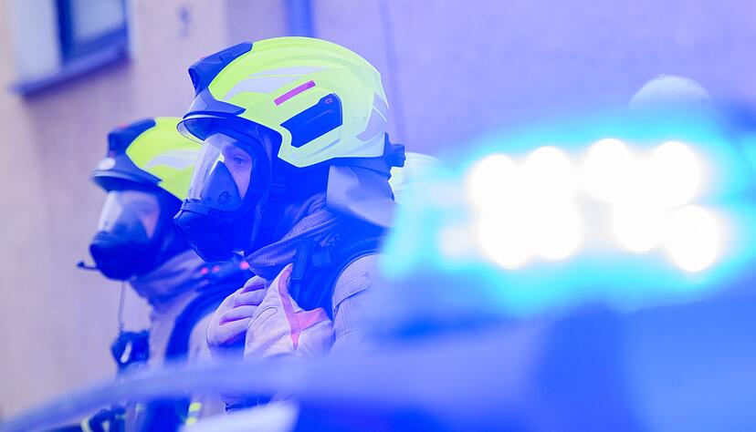 Feuerwehrleute stehen an einem Einsatzort. Feuerwehrleute stehen an einem Einsatzort.