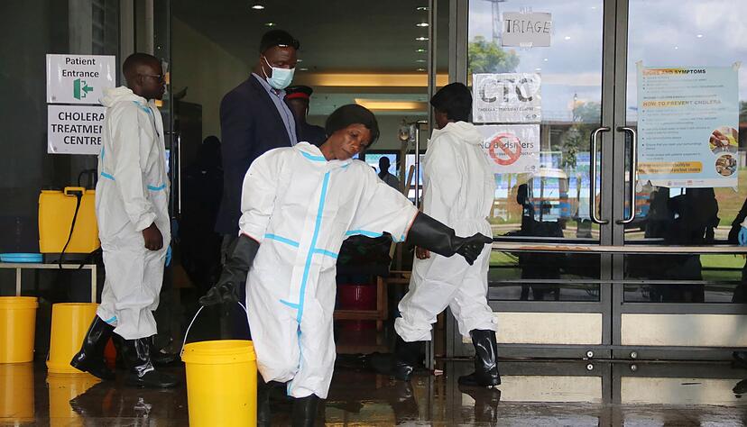 Eine Mitarbeiterin trägt Desinfektionsmittel aus einem Cholera-Behandlungszentrum (Archivbild) Eine Mitarbeiterin trägt Desinfektionsmittel aus einem Cholera-Behandlungszentrum (Archivbild)