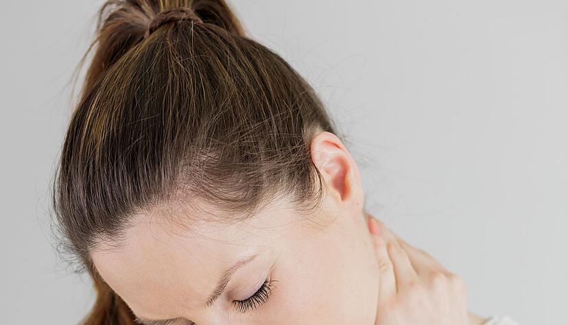 Wer viel mit gesenktem Kopf auf sein Handy sieht, kann auf Dauer schmerzhafte Verspannungen bekommen.