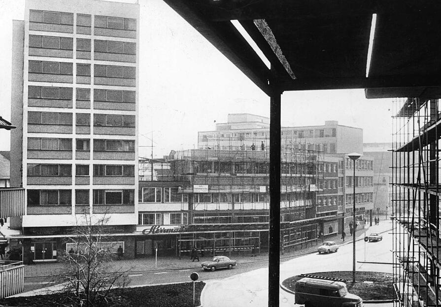Links im Bild ist das Stimme-Hochhaus sichtbar. Der Eingang zur Stimme ist an der Ecke Allee/Synagogengasse. Im Erdgeschoss des Anbaus ist der Juwelier Herrmann ansässig. Daneben wird der Bau um ein weiteres Stockwerk erhöht. Undatierte Aufnahme.