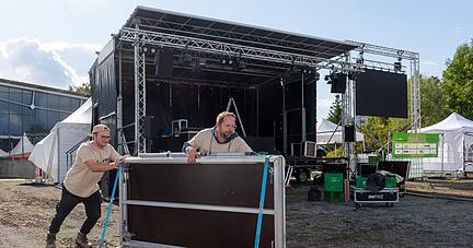 Alle packen mit an: Jonathan Wein und Steffen Heinrich (v.l.) überwachen den Aufbau zum Festival der Zukunft, der seit Donnerstag läuft. Unten: Die wetterfesten Pagodenzelte stellt die Stadt Lauffen. Der Arbeitskreises Klimaschutz klärt über Kleiderkonsum auf, Serina Hirschmann und Silvia Schmid (v.l.) bestücken die Kleiderstange mit Secondhand-Mode.
Fotos: Mario Berger
