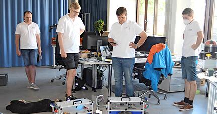 Michael Ball (von links), Jonathan Müller, Benedict Bauer und Patrick Stutz sind stolz auf den Roboter, der Landwirten die Arbeit erleichtern soll.
Foto: Ralf Schick