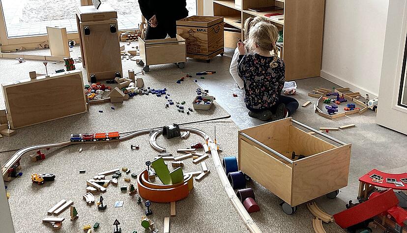 Kinder bauen unter Beaufsichtigung eine Eisenbahn. Alle Funktionsräume haben bodentiefe Fenster, die viel Tageslicht einlassen. Kinder bauen unter Beaufsichtigung eine Eisenbahn. Alle Funktionsräume haben bodentiefe Fenster, die viel Tageslicht einlassen.