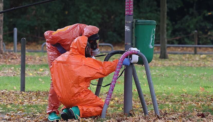 Feuerwehrleute &uuml;berpr&uuml;fen eine M&uuml;lltonne.