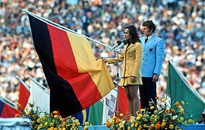 F&uuml;nfk&auml;mpferin Heidi Sch&uuml;ller spricht 1972 f&uuml;r die im M&uuml;nchner Olympiastadion versammelten Sportler den Olympischen Eid. Das sportliche Gro&szlig;ereignis kurbelte den Verkauf von Farbfernsehern an.
Foto: dpa