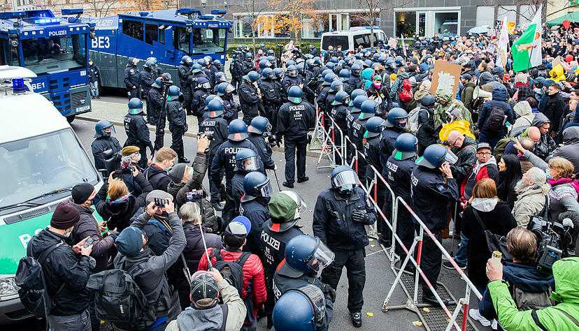 Wasserwerfer der Polizei stehen bei einer Demonstration gegen die Corona-Einschr&auml;nkungen der Bundesregierung zwischen dem Brandenburger Tor und dem Reichstagsgeb&auml;ude an einer Absperrung. Foto: dpa