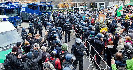 Wasserwerfer der Polizei stehen bei einer Demonstration gegen die Corona-Einschr&auml;nkungen der Bundesregierung zwischen dem Brandenburger Tor und dem Reichstagsgeb&auml;ude an einer Absperrung. Foto: dpa