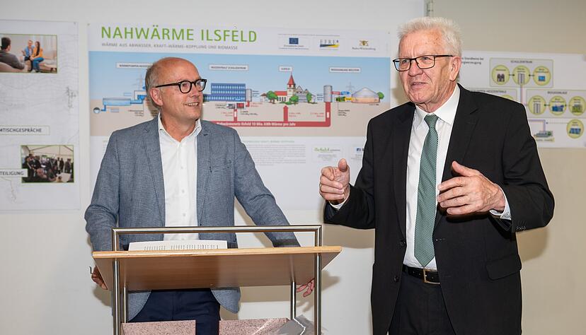 Beispielgebende Antworten auf die Klimakrise sieht Ministerpräsident Winfried Kretschmann in Ilsfeld, wo er sich von Bürgermeister Thomas Knödler (links) die Struktur und Genese des örtlichen Nahwärmenetzes erläutern ließ.