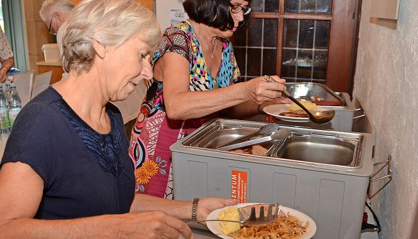 Anna Gasch (vorne) und Heidi Weeber portionieren Fleischk&auml;se, Sp&auml;tzle und Kartoffelsalat f&uuml;r die G&auml;ste. Foto: Stefanie Pf&auml;ffle
