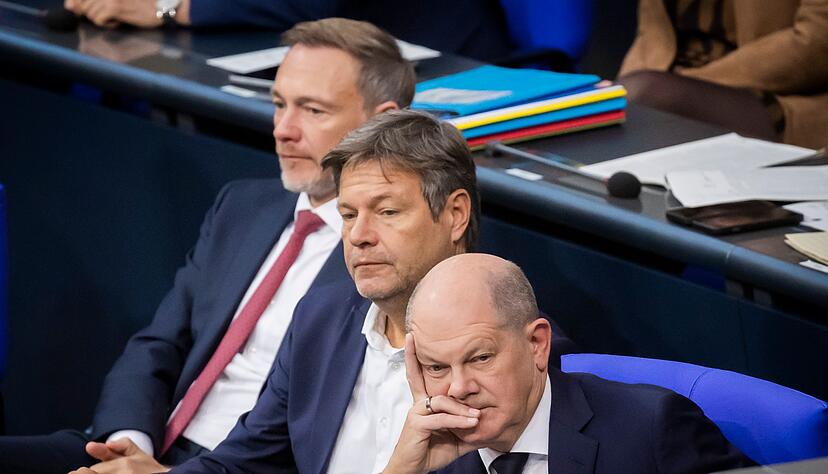 Bundeskanzler Olaf Scholz (SPD, r-l), Wirtschaftsminister Robert Habeck (Bündnis 90/Die Grünen) und Finanzminister Christian Lindner (FDP) verfolgen im Deutschen Bundestag die Debatte.