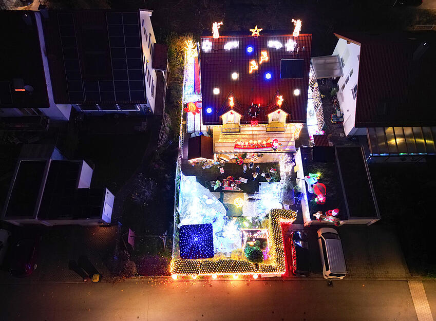 Die Lichter des  Weihnachtshauses erstrahlen in der Vorweihnachtszeit in der Wohnsiedlung.