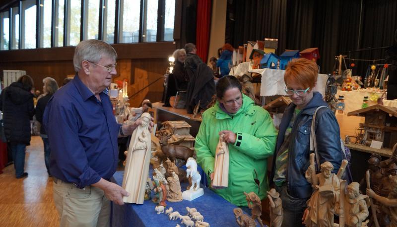 Organisator Walter Schenk zeigt Nicole Potsch (Mitte) und Andrea Erhardt seine in stundenlanger Arbeit geschnitzten Holzfiguren.
Foto: Elke Khattab
