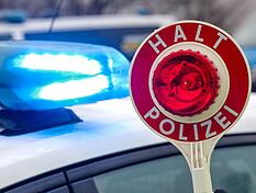 ARCHIV - 05.02.2025, Sachsen, Burgstein: Ein Polizist h&auml;lt eine Polizeikelle f&uuml;r eine Kontrolle auf einem Parkplatz an der Autobahn 72. (zu dpa: &laquo;Alkoholisierter Mann bedroht Lieferanten und Polizei&raquo;) Foto: Jan Woitas/dpa +++ dpa-Bildfunk +++