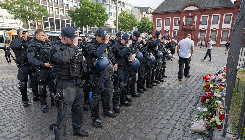 Minuten nach dem Bekanntwerden seines Todes trauern Polizisten auf dem Marktplatz in Mannheim um ihren getöteten Kollegen. Der Polizist war hier von einem Mann mit einem Messer niedergestochen und lebensgefährlich verletzt worden.
