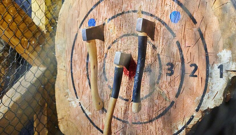 &Auml;xte, geworfen von Julien Vandenitte, Gr&uuml;nder von Wood Cutter Berlin stecken in einer Holzscheibe. Der Freizeittrend Axtwerfen kommt nach Deutschland.