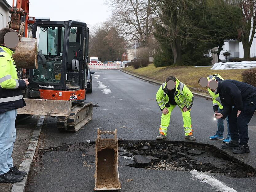 Feuerwehr und Polizei haben die Stra&szlig;e, deren Untergrund durch Wasser untersp&uuml;lt wurde, abgesichert.