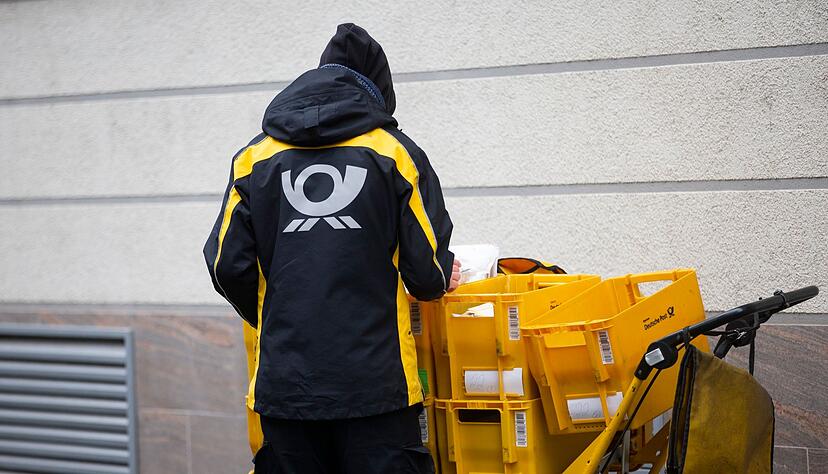 Ein Briefträger der Deutschen Post verteilt Postsendungen (Symbolbild). Ein Briefträger der Deutschen Post verteilt Postsendungen (Symbolbild).