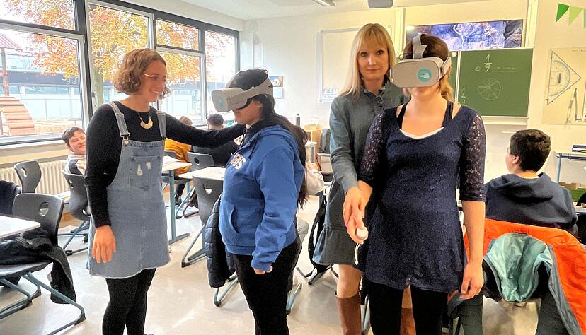 Malak (2.v.l.) und Laura (r.) lernen potenzielle Ausbildungsberufe mit Hilfe von Praktika live, aber auch digital mit VR-Brillen kennen. Ihre Lehrerin Melissa Ammann und Rektorin Lea Grie&szlig;l begleiten sie dabei.