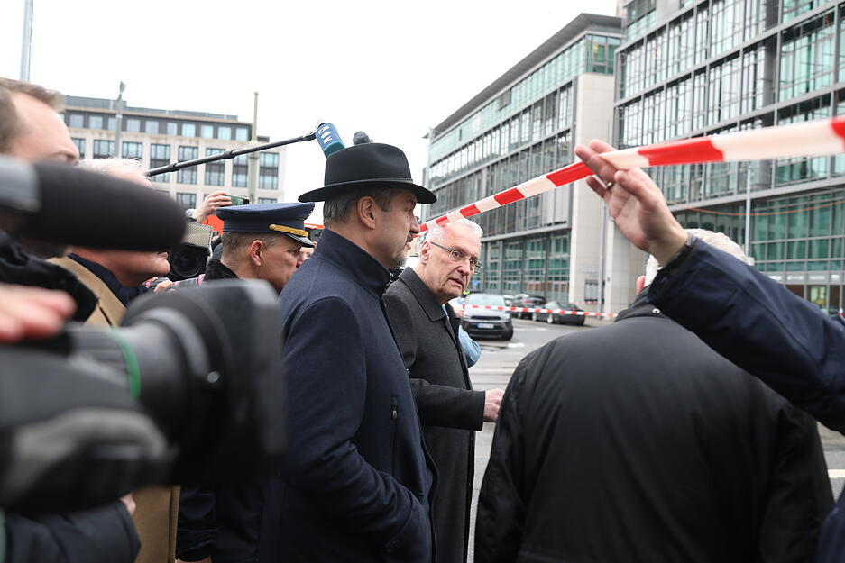 Bayerns Ministerpräsident Markus Söder (CSU, Mitte) und Innenminister Joachim Herrmann (CSU, rechts) besuchen am Donnerstag den Einsatzort in München.