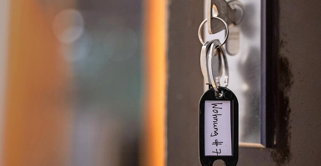 Ein Schl&uuml;ssel mit der Aufschrift &laquo;Wohnung #7&raquo; h&auml;ngt an einer Wohnungseingangst&uuml;r. (gestellte Szene)