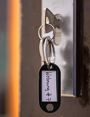 Ein Schl&uuml;ssel mit der Aufschrift &laquo;Wohnung #7&raquo; h&auml;ngt an einer Wohnungseingangst&uuml;r. (gestellte Szene)