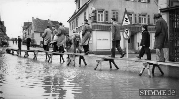 Mai 1978: Hochwasser in Bad Friedrichshall-Kochendorf. Anwohner müssen die Straße über einen Steg queren. Mai 1978: Hochwasser in Bad Friedrichshall-Kochendorf. Anwohner müssen die Straße über einen Steg queren.