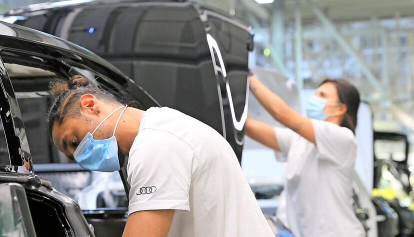Audi-Mitarbeiter in der Halle A13 bei der Montage von A6 und A7: Hier wird &minus; von kurzen Pausen abgesehen &minus; durchgehend mit Mund-Nase-Schutz gearbeitet.
Audi/Belz