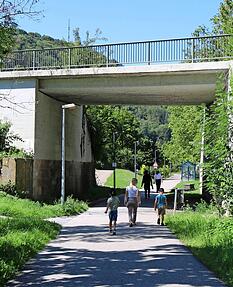 Menschen schlendern auf dem Fuß- und Radweg in Richtung des Künzelsauer Bahnhofs. Hier könnte die Kochertalbahn im Fall einer Reaktivierung irgendwann wie einst wieder unter der Stuttgarter Straße (B19) hindurchfahren.
Foto: Tamara Ludwig