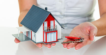 Ein Makler für Immobilien mit einem Haus und einem Schlüssel. Erfolgreiche Vermietung und Hausverkauf durch Immobilienmakler.