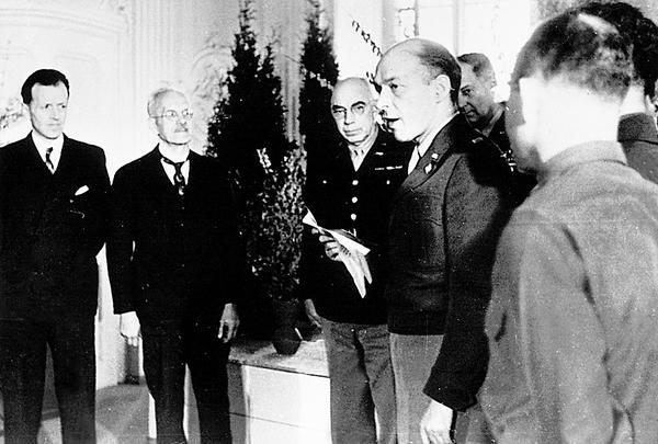 Das Erscheinen der 1. Ausgabe der Heilbronner Stimme am 28.3.1946 wird mit einem Festakt im Schie&szlig;haus in der Heilbronner Bahnhofsvorstadt  eingeleitet. US-Sergeant Gengian &uuml;bergibt die 31. Zeitungslizenz in der US-Besatzungszone an die Herausgeber (v. l.) Hermann Schwerdtfeger und Paul Distelbarth.