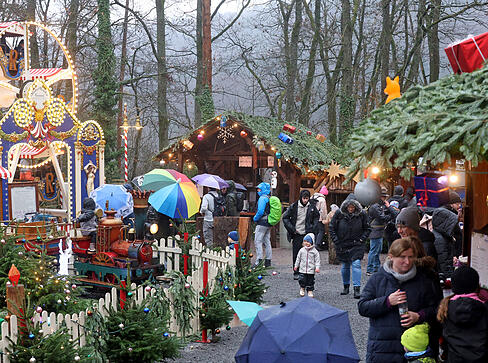 Lichterketten und winterliche Dekoration schaffen eine festliche Atmosphäre im Park.