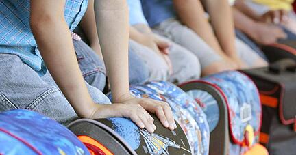 Mehrere Erstklässler warten auf ihre Einschulung in eine Grundschule.