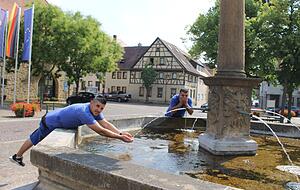 Abk&uuml;hlung gef&auml;llig? Ardam Turukman und Shakir Rami haben gerade die Fenster der Sparkasse geputzt. Jetzt tut das k&uuml;hle Wasser gut.