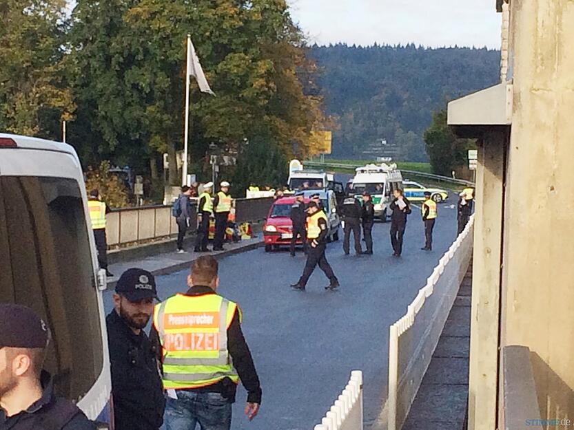 Fünf Demonstranten haben sich an das Geländer über den Neckar bei der Schleuse Gundelsheim gekettet. Polizeibeamte versuchen, sie von dort zu entfernen.