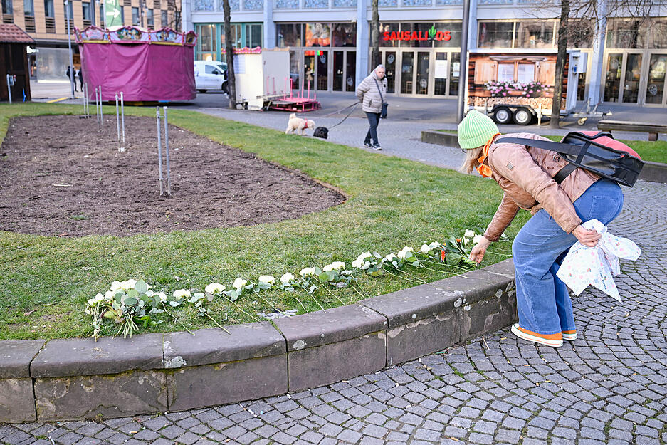 Eine Frau legt in der Nähe des Mannheimer Paradeplatzes Blumen auf eine Grünfläche. Am Rosenmontag war hier ein Auto in eine Menschenmenge gefahren. Zwei Personen wurden tödlich und mehrere schwer verletzt. Eine Frau legt in der Nähe des Mannheimer Paradeplatzes Blumen auf eine Grünfläche. Am Rosenmontag war hier ein Auto in eine Menschenmenge gefahren. Zwei Personen wurden tödlich und mehrere schwer verletzt.