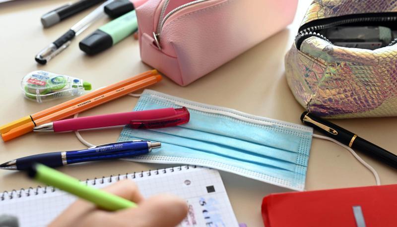 Ein Mund-Nasen-Schutz liegt auf dem Tisch einer Sch&uuml;lerin.