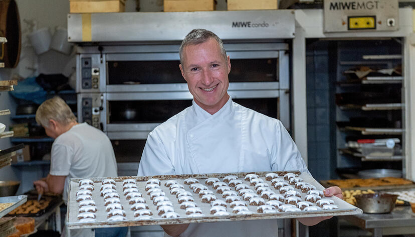 Gleich schiebt Thomas Sammet die fertig ausgestochenen Zimtsterne in den Ofen. W&auml;hrenddessen spritzt Gudrun Pietschmann-Haag Nougat auf Sandgeb&auml;ck.
