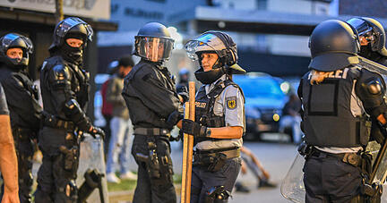Eine Polizistin trägt nach Ausschreitungen bei einer Eritrea-Veranstaltung Holzstangen weg. Bis zu 200 Personen hätten Teilnehmer der Veranstaltung und Polizisten mit Steinen, Flaschen und Holzlatten angegriffen, teilte ein Polizeisprecher mit. Zehn Beamte seien verletzt worden.