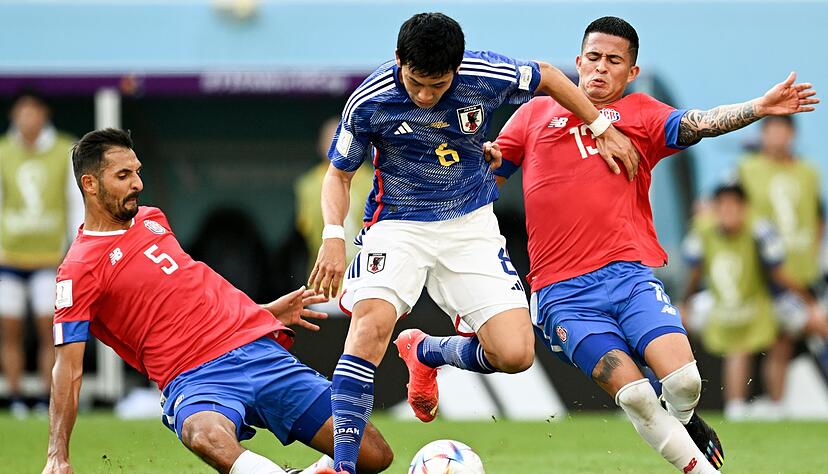 Der Japaner Wataru Endo (M) wird von Costa Ricas Celso Borges (l) und Gerson Torres (r) in die Zange genommen.