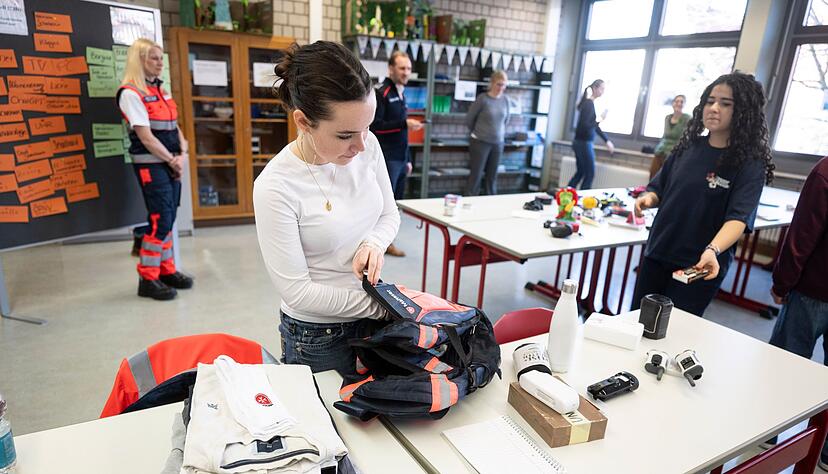 Die Schülerinnen und Schüler packen einen Notfallrucksack zusammen. Die Schülerinnen und Schüler packen einen Notfallrucksack zusammen.
