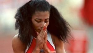 Florence Griffith-Joyner kniet nach ihrem 200m-Erfolg 1988 auf der Tartanbahn von Seoul.