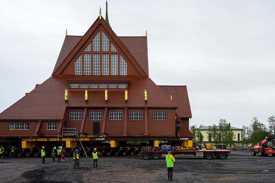 Bauarbeiter und Medienvertreter stehen in der N&auml;he der Kiruna-Kirche &ndash; alles bereit f&uuml;r den Abtransport.