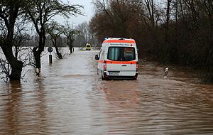 Ein Krankenwagen fährt über eine von Hochwasser überflutete Straße nach Windehausen in Thüringen. Ein Krankenwagen fährt über eine von Hochwasser überflutete Straße nach Windehausen in Thüringen.