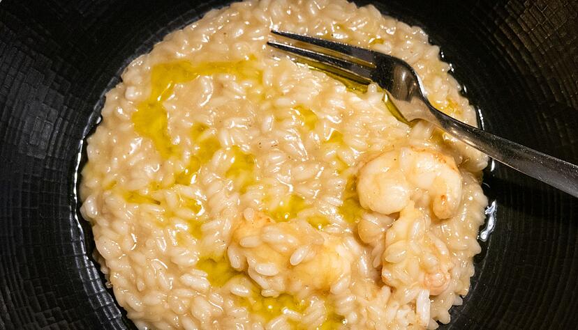Kurz vorm Servieren gibt K&uuml;chenchef Kruno Kapetanović noch einen Schuss Oliven&ouml;l &uuml;ber das Scampi-Risotto.