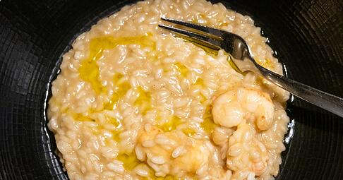 Kurz vorm Servieren gibt K&uuml;chenchef Kruno Kapetanović noch einen Schuss Oliven&ouml;l &uuml;ber das Scampi-Risotto.