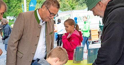 Minister Peter Hauk und sein Sohn Max studieren beim Walderlebnistag verschiedene Moos-Sorten am Stand von Michael Wennes.
Foto: Mario Berger